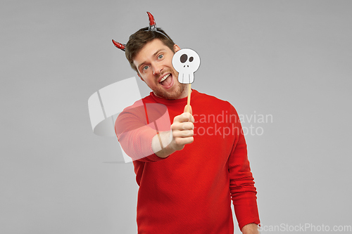 Image of happy man in halloween costume of devil over grey