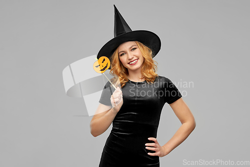 Image of woman in halloween costume of witch with pumpkin