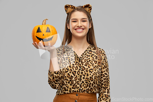 Image of woman in halloween costume of leopard with pumpkin