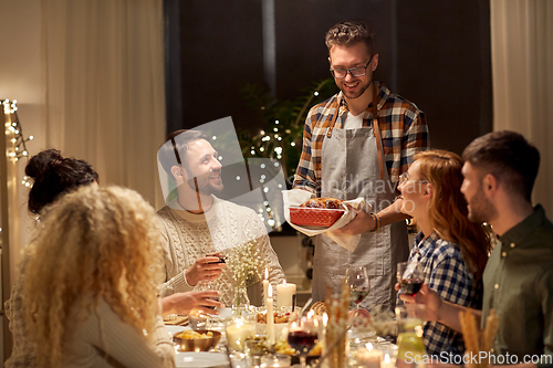 Image of happy friends having christmas dinner at home