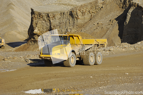 Image of A yellow dump truck is working