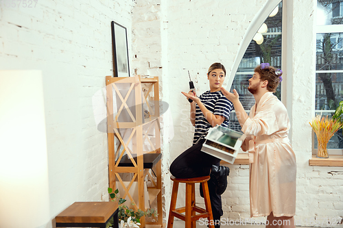 Image of Gender stereotypes. Wife and husband doing things unusual for their genders in social meanings