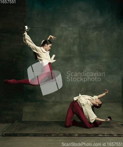 Image of Two young female ballet dancers like duelists with swords. Ballet and contemporary choreography concept. Creative art photo.