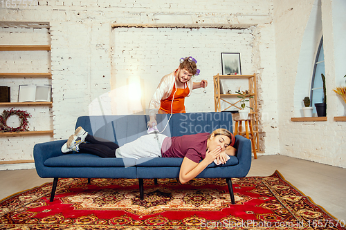 Image of Gender stereotypes. Wife and husband doing things unusual for their genders in social meanings