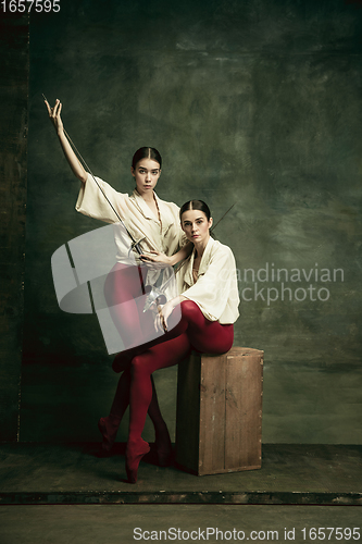 Image of Two young female ballet dancers like duelists with swords. Ballet and contemporary choreography concept. Creative art photo.