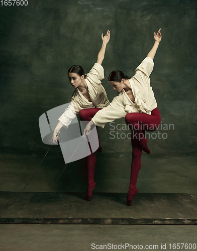 Image of Two young female ballet dancers like duelists with swords. Ballet and contemporary choreography concept. Creative art photo.