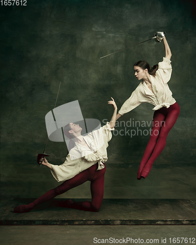 Image of Two young female ballet dancers like duelists with swords. Ballet and contemporary choreography concept. Creative art photo.