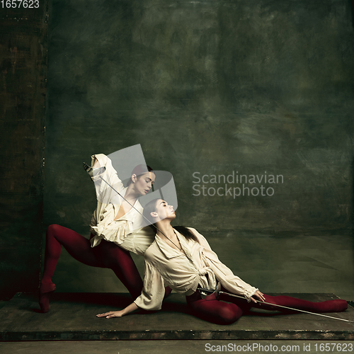 Image of Two young female ballet dancers like duelists with swords. Ballet and contemporary choreography concept. Creative art photo.