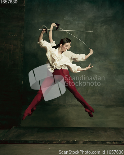 Image of Two young female ballet dancers like duelists with swords. Ballet and contemporary choreography concept. Creative art photo.