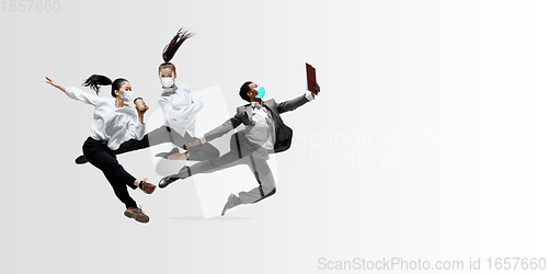Image of Happy office workers in face masks jumping and dancing in casual clothes or suit isolated on studio background. Creative collage.