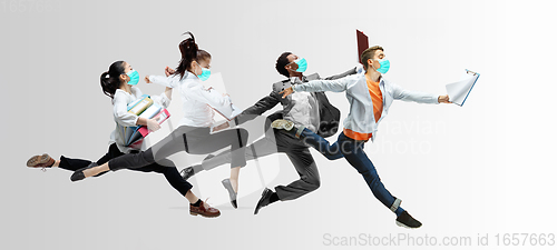 Image of Happy office workers in face masks jumping and dancing in casual clothes or suit isolated on studio background. Creative collage.