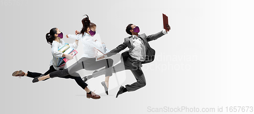 Image of Happy office workers in face masks jumping and dancing in casual clothes or suit isolated on studio background. Creative collage.