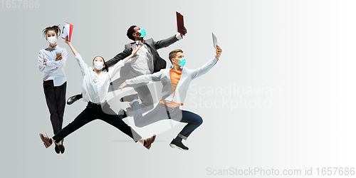 Image of Happy office workers in face masks jumping and dancing in casual clothes or suit isolated on studio background. Creative collage.