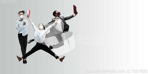 Image of Happy office workers in face masks jumping and dancing in casual clothes or suit isolated on studio background. Creative collage.