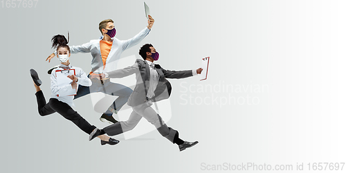 Image of Happy office workers in face masks jumping and dancing in casual clothes or suit isolated on studio background. Creative collage.