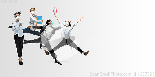 Image of Happy office workers in face masks jumping and dancing in casual clothes or suit isolated on studio background. Creative collage.