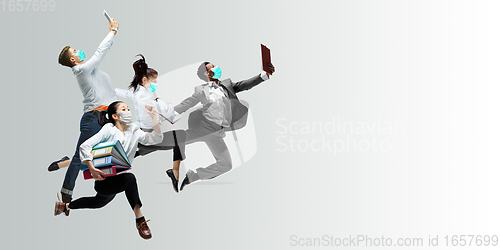 Image of Happy office workers in face masks jumping and dancing in casual clothes or suit isolated on studio background. Creative collage.