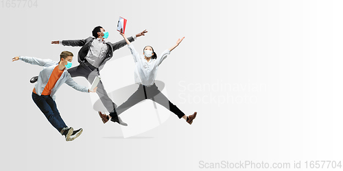 Image of Happy office workers in face masks jumping and dancing in casual clothes or suit isolated on studio background. Creative collage.