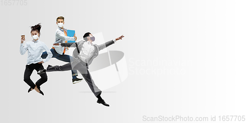 Image of Happy office workers in face masks jumping and dancing in casual clothes or suit isolated on studio background. Creative collage.