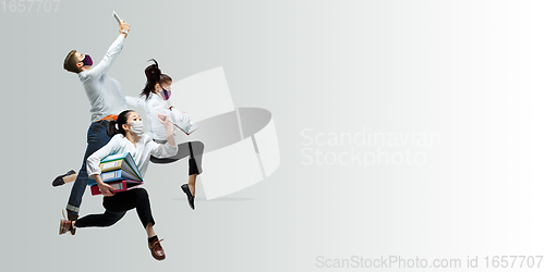 Image of Happy office workers in face masks jumping and dancing in casual clothes or suit isolated on studio background. Creative collage.