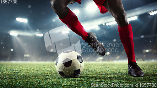 Image of Young man football player kicking ball during match at stadium. Flyer for ad, design.