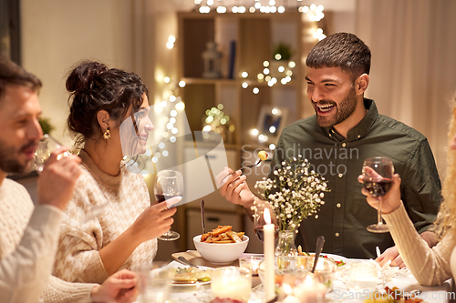Image of happy friends having christmas dinner at home