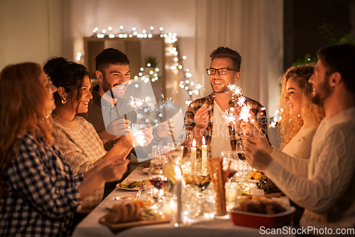 Image of happy friends having christmas dinner at home