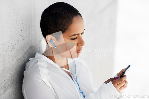 Image of african american woman with earphones and phone