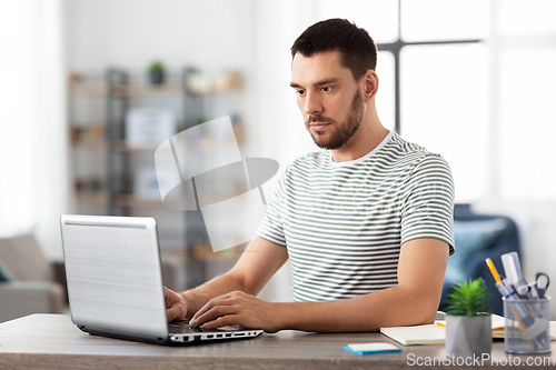 Image of man with laptop working at home office