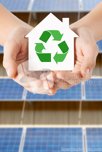 Image of hands holding house with recycling symbol