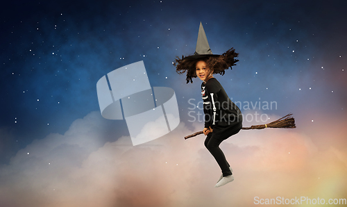 Image of girl in black witch hat with broom on halloween