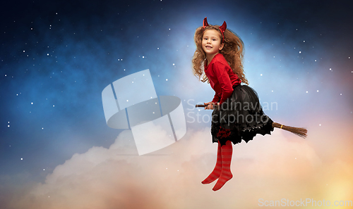 Image of girl in halloween costume flying on witch's broom