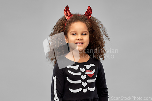 Image of girl in black dress and devil's horns on halloween