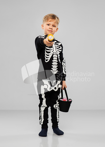 Image of boy with candies and flashlight on halloween