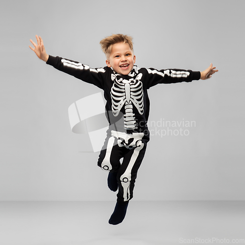 Image of happy boy in halloween costume of skeleton jumping