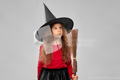 Image of girl in black witch hat with broom on halloween