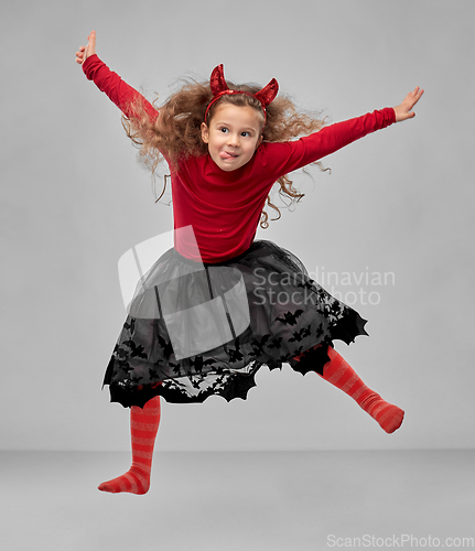 Image of girl in halloween costume of devil jumping