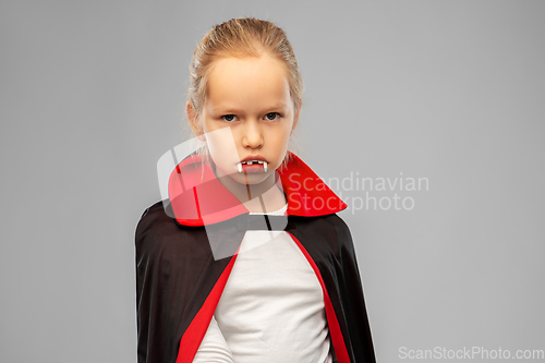 Image of girl in dracula costume with cape on halloween