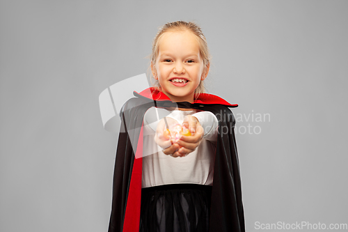 Image of girl in halloween costume of dracula with candies