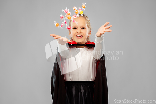 Image of girl in halloween costume of dracula with candies