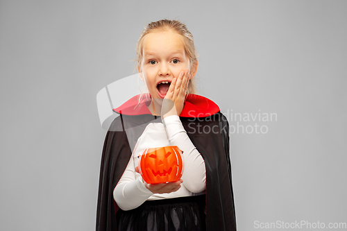 Image of girl in halloween costume of dracula with pumpkin