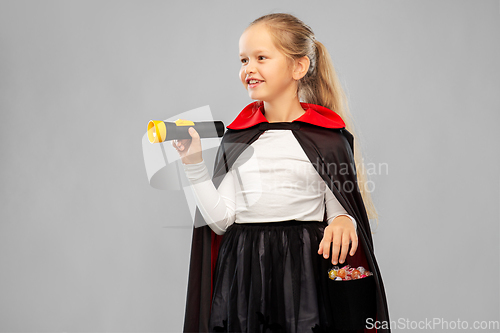 Image of girl in halloween costume of dracula with candies