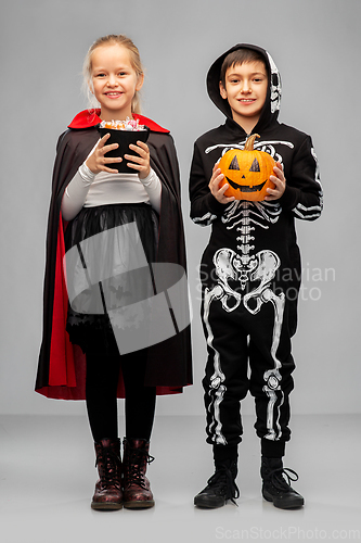 Image of happy children in halloween costumes with candies