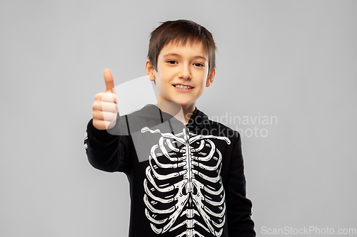 Image of boy in halloween skeleton costume shows thumbs up