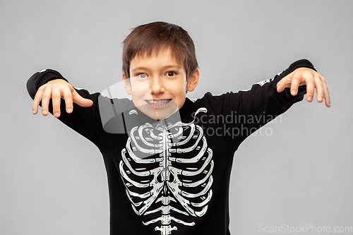 Image of boy in halloween costume of skeleton frightening