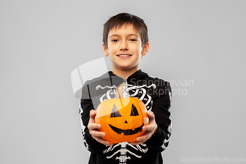 Image of boy in halloween costume of skeleton with pumpkin