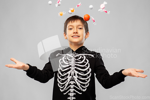 Image of boy in halloween costume of skeleton with candies