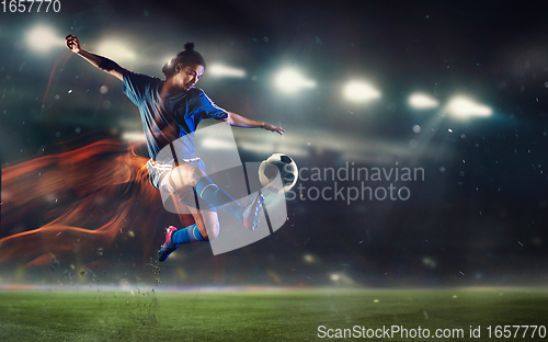 Image of Young man football player kicking ball during match at stadium. Flyer for ad, design.