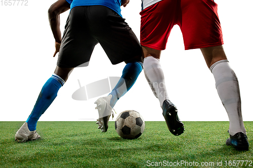 Image of Close up legs of professional soccer, football players fighting for ball on field isolated on white background