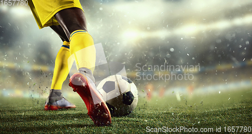 Image of Young man football player kicking ball during match at stadium. Flyer for ad, design.